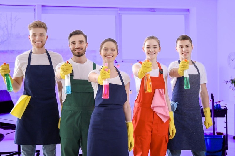 The Dust Detectives cleaning team holding spray bottles